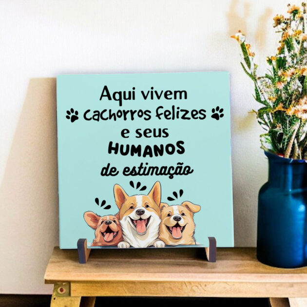 Azulejo decorativo com a frase Aqui vivem cachorros felizes e seus humanos de estimação com o desenho de três cachorrinhos