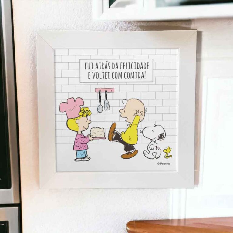 Na foto um azulejo decorativo criativo e engraçado com desenho do Snoopy com um boné e o woodstock em uma cozinha com louças na pia. No azulejo tem a frase enquanto houver vida haverá louça na pia.