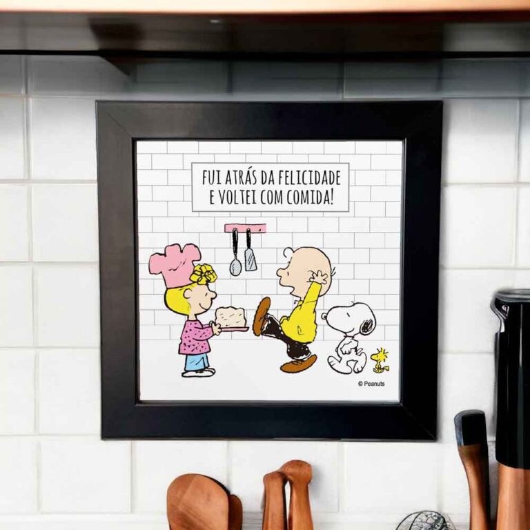 Na foto um azulejo decorativo criativo e engraçado com desenho do Snoopy com um boné e o woodstock em uma cozinha com louças na pia. No azulejo tem a frase enquanto houver vida haverá louça na pia.