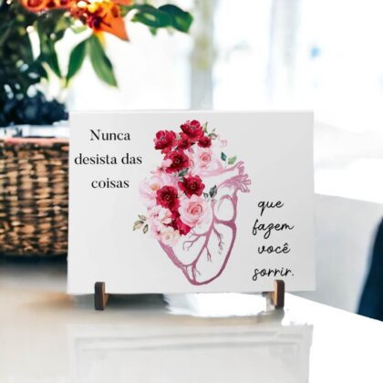 Azulejo decorativo com a frase Nunca desista das coisas que fazem você sorrir com desenho de um coração com flores