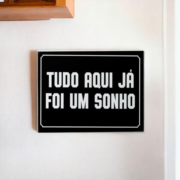 Azulejo decorativo com a frase Tudo aqui já foi um sonho com o fundo preto