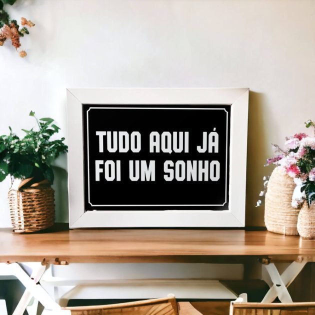 Azulejo decorativo com a frase Tudo aqui já foi um sonho com o fundo preto