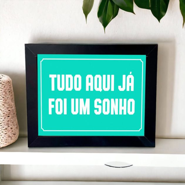 Azulejo decorativo com a frase Tudo aqui já foi um sonho com o fundo azul claro