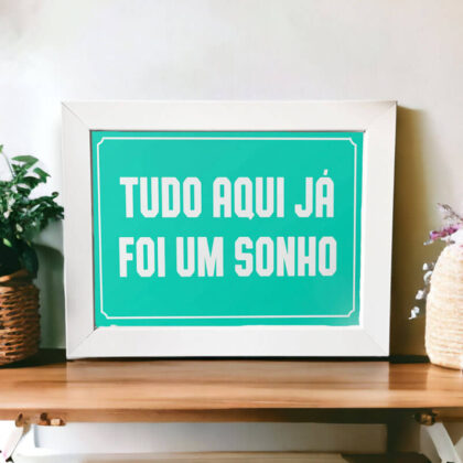 Azulejo decorativo com a frase Tudo aqui já foi um sonho com o fundo azul claro