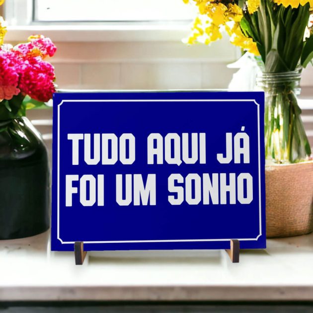 Azulejo decorativo com a frase Tudo aqui já foi um sonho com o fundo azul marinho