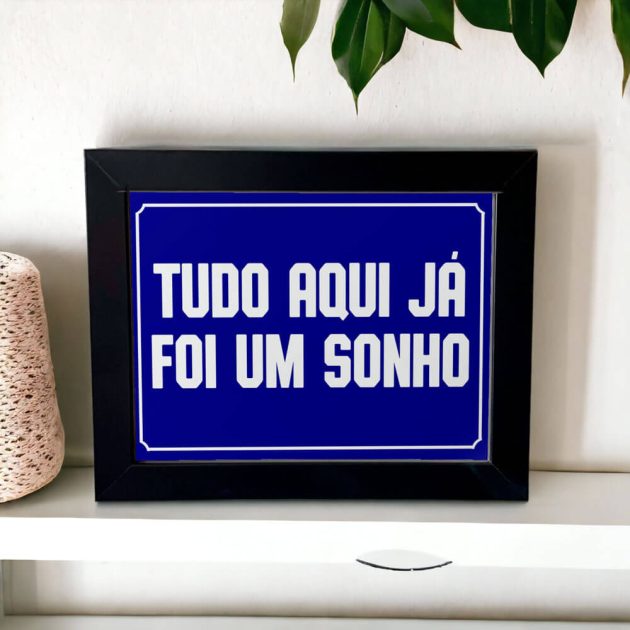 Azulejo decorativo com a frase Tudo aqui já foi um sonho com o fundo azul marinho