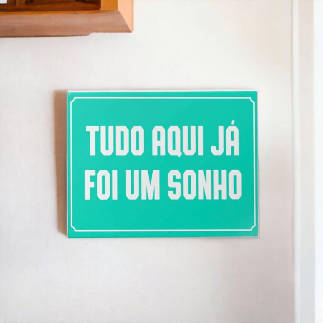 Azulejo decorativo com a frase Tudo aqui já foi um sonho com o fundo azul claro