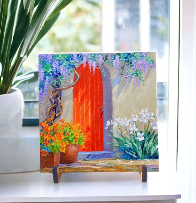 Azulejo decorativo com o desenho de uma porta laranja com flores lilás - Coleção Encantos