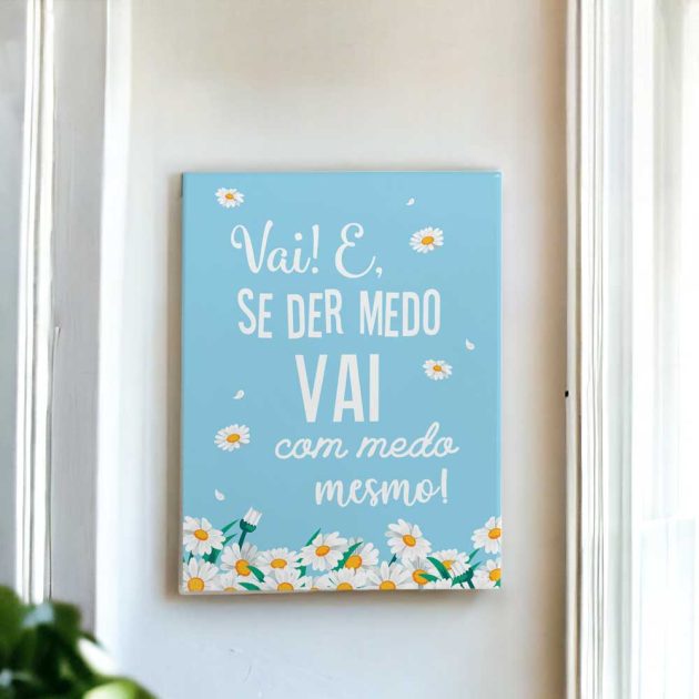 Azulejo decorativo com a frase Vai e se der medo vai com medo mesmo no tom azul com margaridas