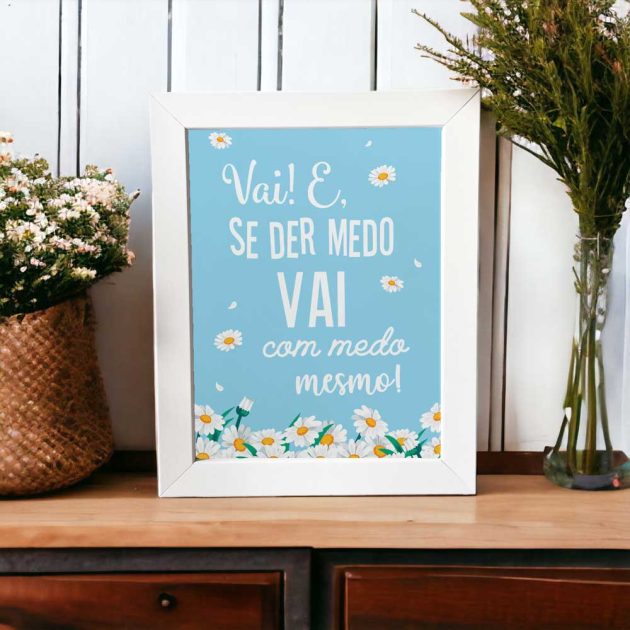 Azulejo decorativo com a frase Vai e se der medo vai com medo mesmo no tom azul com margaridas