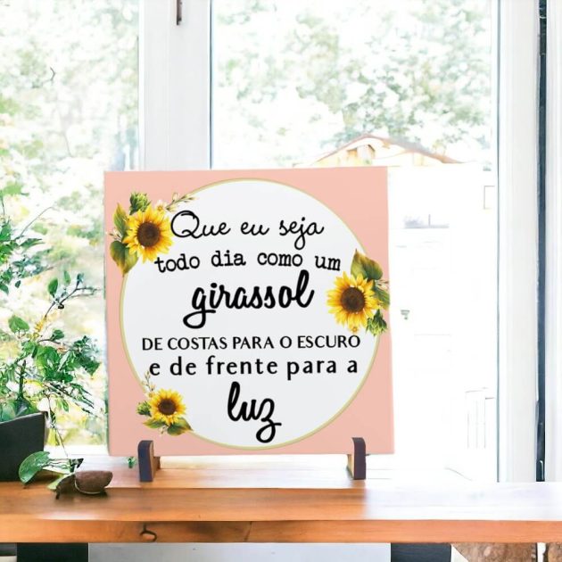 Azulejo decorativo com a frase Que eu seja todo dia como um Girassol de costas para o escuro e de frente para a luz com um fundo rosa floral