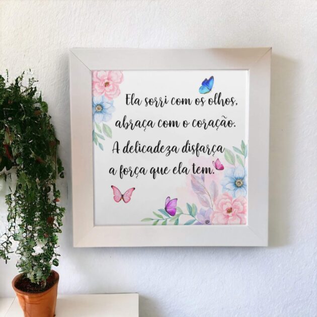 Azulejo decorativo com a frase Ela sorri com os olhos, abraça com o coração. A delicadeza disfarça a força que ela tem