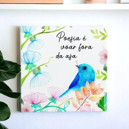 Azulejo decorativo com a frase Poesia é voar fora da asa com o desenho de um pássaro em um jardim