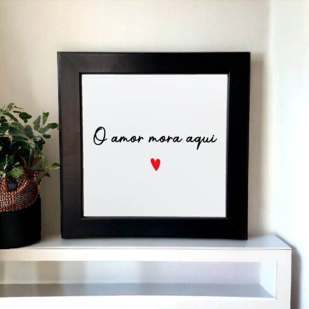 Azulejo decorativo com a frase O amor mora aqui com um coração vermelho