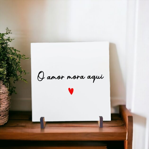 Azulejo decorativo com a frase O amor mora aqui com um coração vermelho