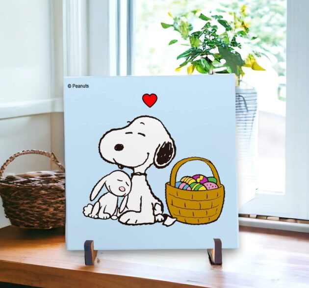 Azulejo decorativo do Snoopy com uma cesta cheia de ovos com o fundo azul claro