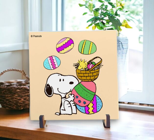 Azulejo decorativo do Snoopy e Woodstock com ovos de coloridos com fundo laranja claro