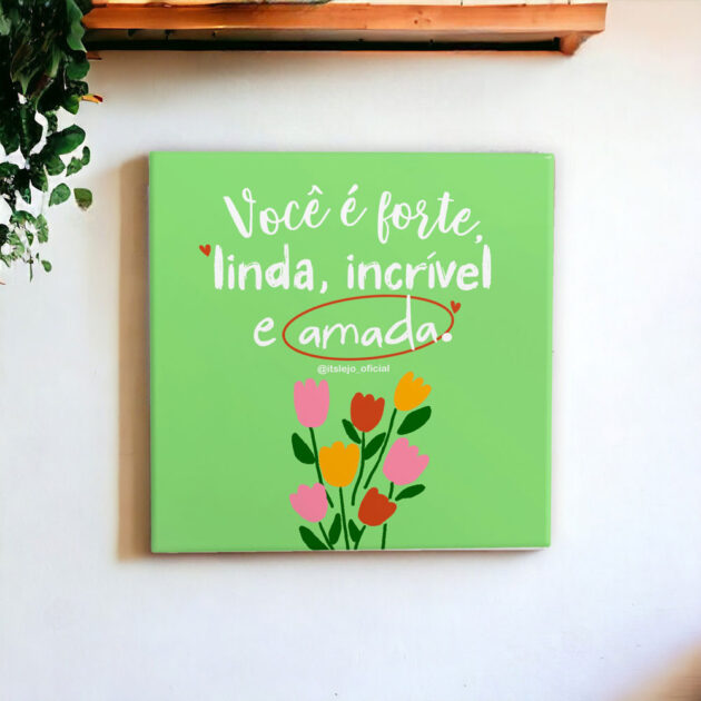 Azulejo decorativo com a frase Você é forte, linda, incrível e amada com o desenho de umas tulipas coloridas com o fundo verde