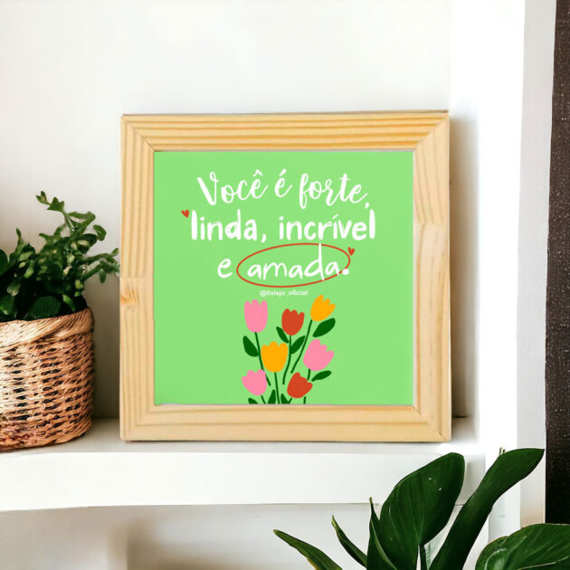 Azulejo decorativo com a frase Você é forte, linda, incrível e amada com o desenho de umas tulipas coloridas com o fundo verde